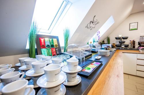a buffet with cups and plates on a counter at Die Schlafstube - Bed & Breakfast in Zeltweg