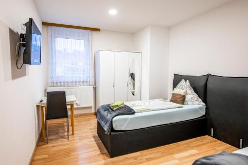 a small bedroom with a bed and a desk at Die Schlafstube - Bed & Breakfast in Zeltweg