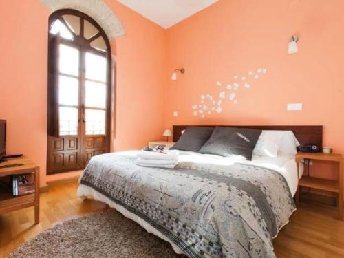 - une chambre avec un mur orange et un lit dans l'établissement Spectacular central Penthouse with private terrace, à Séville