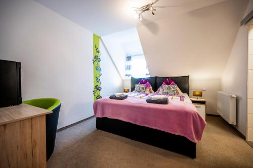 a bedroom with a large bed with a pink blanket at Die Schlafstube - Bed & Breakfast in Zeltweg