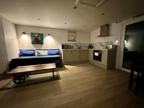 uma sala de estar com um sofá e uma cozinha em Bothy Farm Stay Sleeps 2 HotTub and Pool Table Children Welcome Ayrshire Rural Retreats em Newmilns