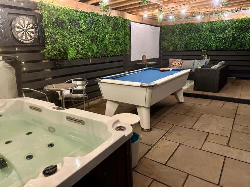 a room with a tub and a pool table at Bothy Farm Stay Sleeps 2 HotTub and Pool Table Children Welcome Ayrshire Rural Retreats in Newmilns