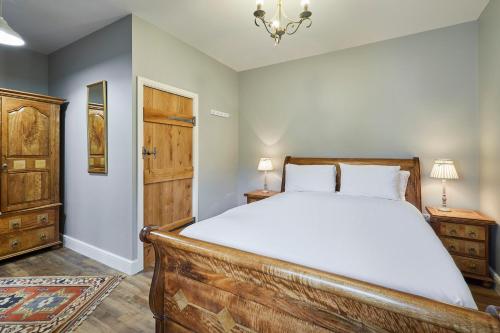 a bedroom with a wooden bed and a chandelier at Host & Stay - Butterfly Cottage 