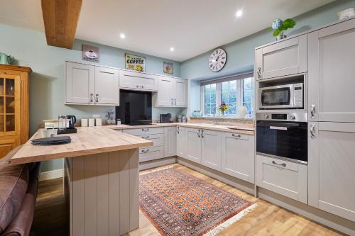 a kitchen with white cabinets and a counter top at Host & Stay - Butterfly Cottage 