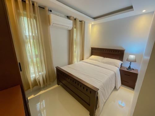 a small bedroom with a bed and a window at Saffire Beach Resort and Glamping in Pagudpud
