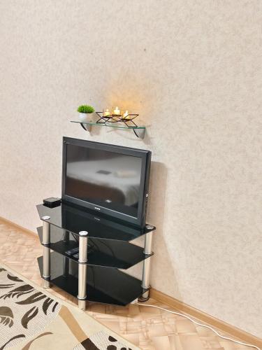 a tv sitting on a stand in a room at Квартира in Almaty