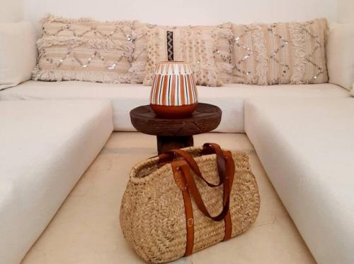 una mesa con una bolsa junto a un sofá en Riad Nour, Maison de charme., en Marrakech