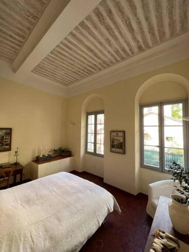 une chambre avec un grand lit et deux fenêtres dans l'établissement Le Refuge - Superbe Duplex avec terrasse, à Tourrettes