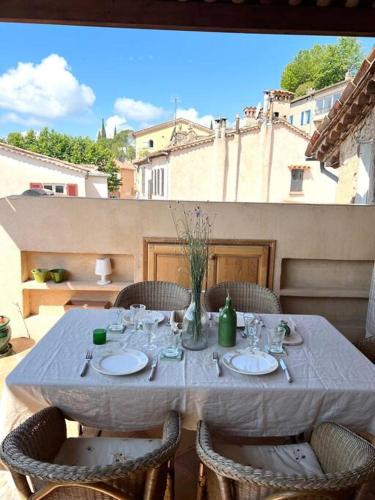 - une table avec des chaises et un chiffon de table blanc sur la terrasse dans l'établissement Le Refuge - Superbe Duplex avec terrasse, à Tourrettes