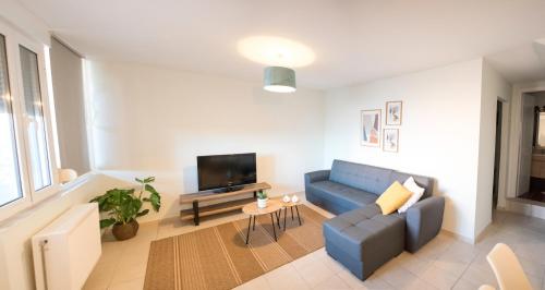 a living room with a blue couch and a tv at Leggero in Preveza
