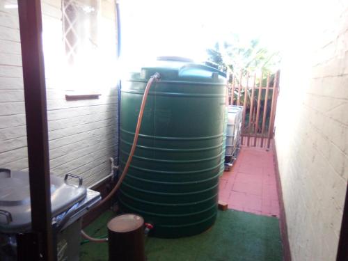 a row of green water tanks sitting in a room at Casa Villa Guest House in Carletonville