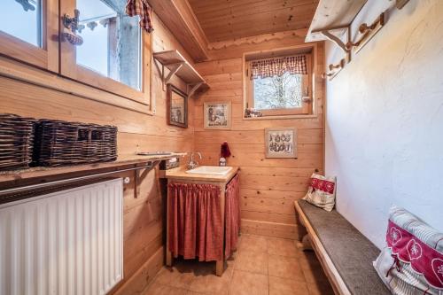 baño con lavabo y banco en una cabaña de madera en Chalet Sun River - 8 pers, en Morzine