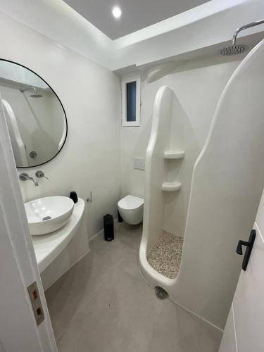a white bathroom with a sink and a toilet at Konstantza's Elegant Apartment in Naxos Chora