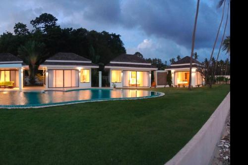 a house with a swimming pool in the yard at Baan Tasha in Laem Sor