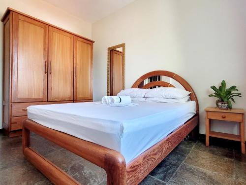 a bedroom with a large bed with a wooden headboard at Melhor Localização para WSL in Saquarema