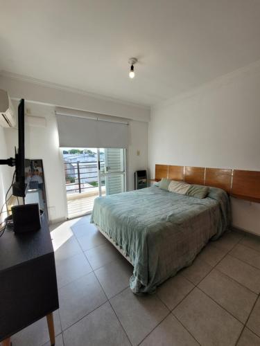 a bedroom with a bed and a desk and a window at Amplio Monoambiente con buena ubicación in Paraná