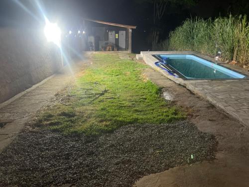 una piscina por la noche con una luz al lado en Espaço Diniz, en Santa Luzia