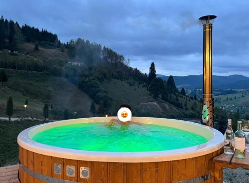 a jacuzzi tub with a person in the water at Pensiunea Poiana Izvoarelor in Vatra Dornei