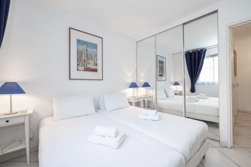 - une chambre blanche avec 2 lits et un miroir dans l'établissement NEW 2 bed apt in Antibes, 5 min walk to the Beach, à Antibes