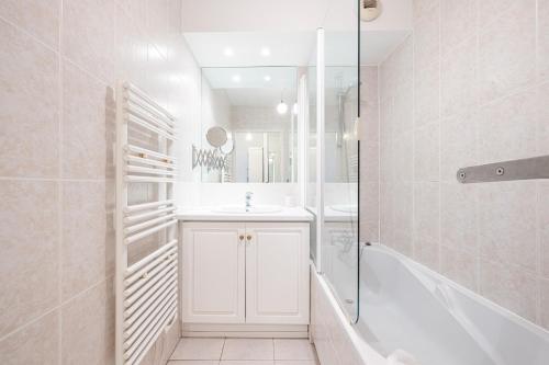 une salle de bain blanche avec un lavabo et une douche dans l'établissement NEW 2 bed apt in Antibes, 5 min walk to the Beach, à Antibes