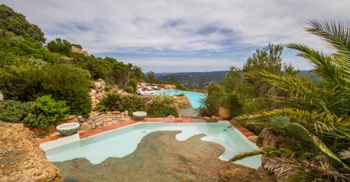 une image d'une piscine dans un jardin dans l'établissement Domaine de Piscia, à Figari