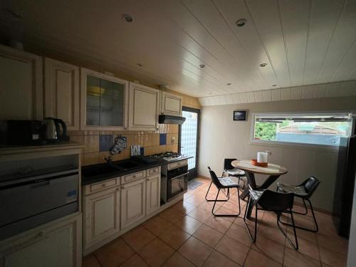 uma cozinha com uma pequena mesa e cadeiras em Appartement type loft avec terrasse em Cherbourg en Cotentin