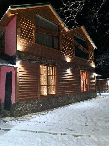 a log home in the snow at night at Villa Maxi Likani in Borjomi