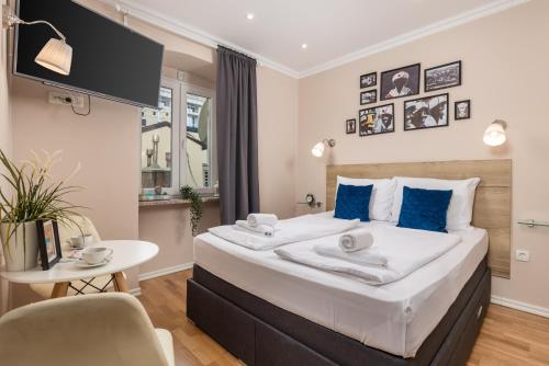a bedroom with a large bed with blue pillows at Apartments Neo in Rijeka