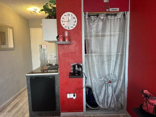 une cuisine avec un évier et une horloge murale dans l'établissement Village naturiste - Studio Port-Soleil - Le rouge, au Cap d'Agde