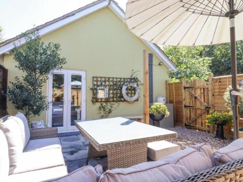 a patio with a table and an umbrella at Pantiles in Eyke