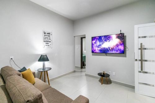 a living room with a couch and a tv on the wall at Casa Água Branca, Contagem - prox.arena MRV in Contagem