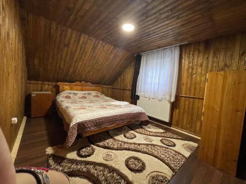 a small room with a bed and a rug at Cabana SVA in Bilbor