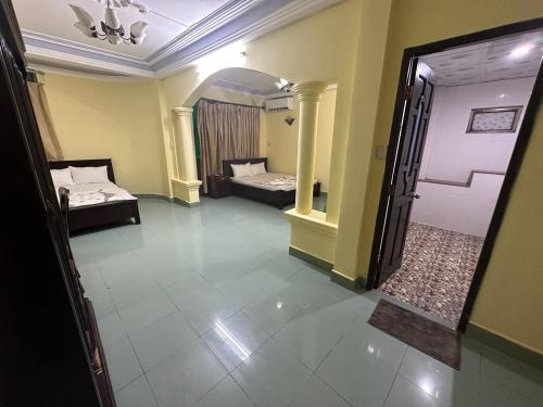 a room with two beds and a hallway with a door at Khách Sạn Ngân Hà in Ho Chi Minh City