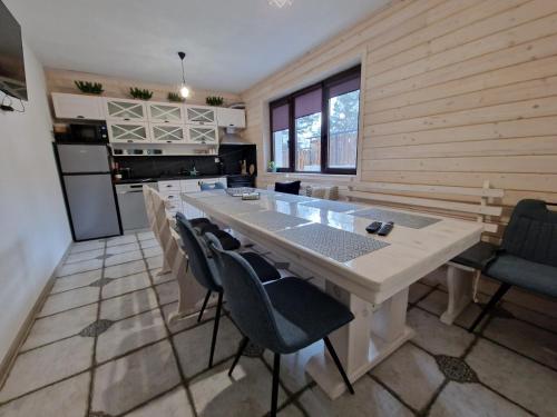 een keuken met een tafel en stoelen in een kamer bij Rodopi Guest House in Tsigov Chark