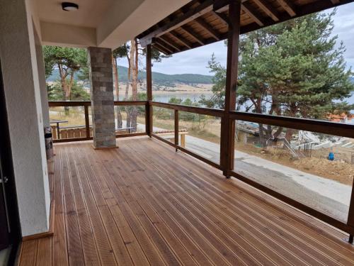 a porch of a house with a wooden deck at Rodopi Guest House in Tsigov Chark