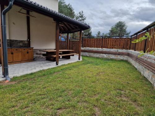 a backyard with a wooden pavilion and a bench at Rodopi Guest House in Tsigov Chark