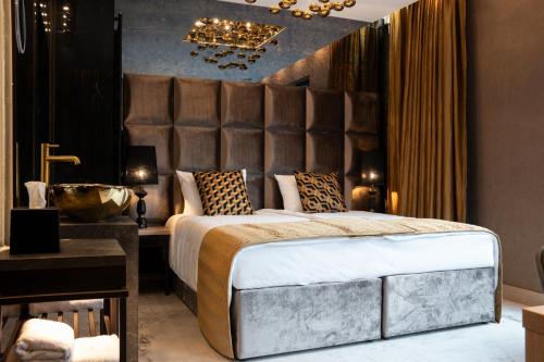 a bedroom with a large bed and a bathroom at Art Suites Luxury Hotel in Kraków