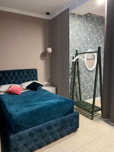 a bedroom with a blue bed and a mirror at Wellconect in Kutaisi