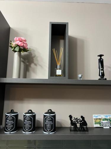 a shelf with three black candles and a mirror at Wellconect in Kutaisi