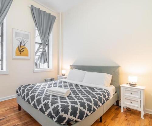 a bedroom with a bed with a black and white comforter at Splendid 2 Bedroom apartment in NYC! in New York