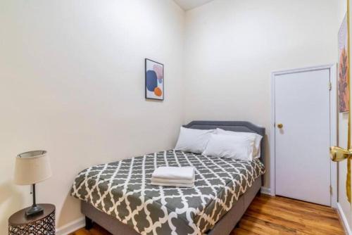 um quarto com uma cama com um edredão preto e branco em Splendid 2 Bedroom apartment in NYC! em Nova York