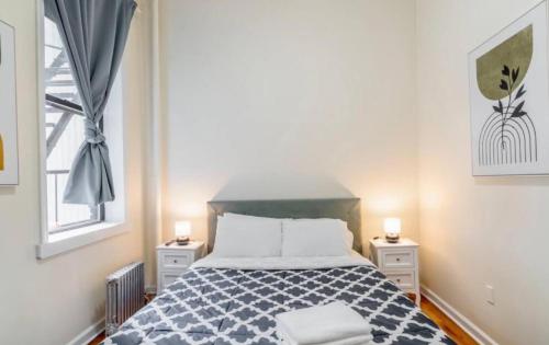 a bedroom with a bed with two nightstands and a window at Splendid 2 Bedroom apartment in NYC! in New York