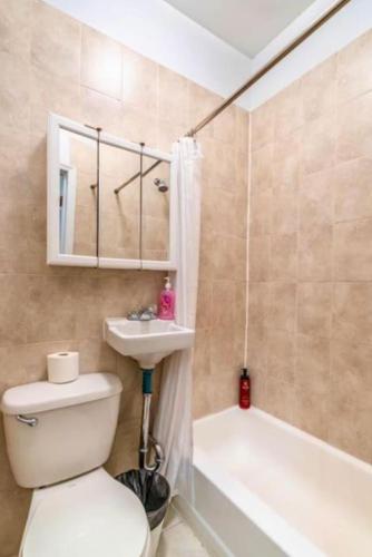 Splendid 2 Bedroom apartment in NYC! في نيويورك: حمام مع مرحاض ومغسلة وحوض استحمام