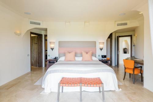 a bedroom with a large bed with pink pillows at Hotel Pitrizza, Costa Smeralda in Porto Cervo