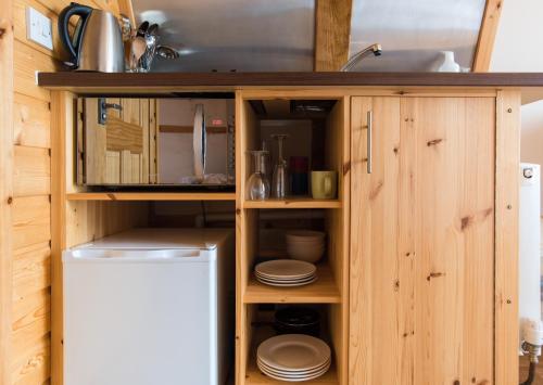 uma cozinha com armários de madeira e um lavatório em Eco Pod 1 At Tapnell Farm em Yarmouth