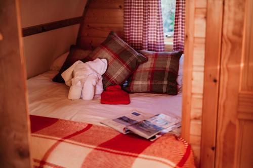 a small bed with a stuffed animal on it at Eco Pod 1 At Tapnell Farm in Yarmouth