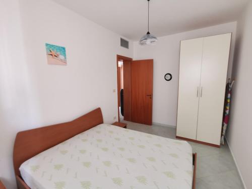 a bedroom with a bed and a closet and a door at Villetta Borgo Pescatori in Torre Pali 