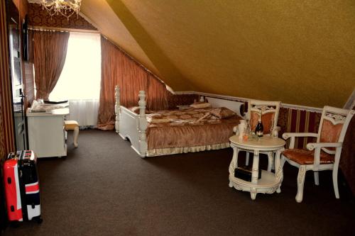 a bedroom with a bed and a table and chairs at Golden Palace in Dubove