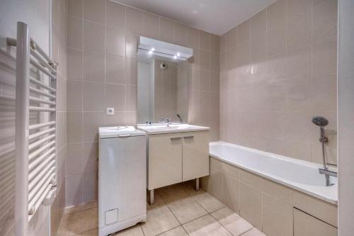 uma casa de banho branca com um lavatório e uma banheira em l'Éclat Contemporain em Seyssinet-Pariset
