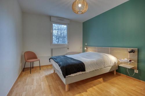 a bedroom with a bed and a window and a chair at l'Éclat Contemporain in Seyssinet-Pariset